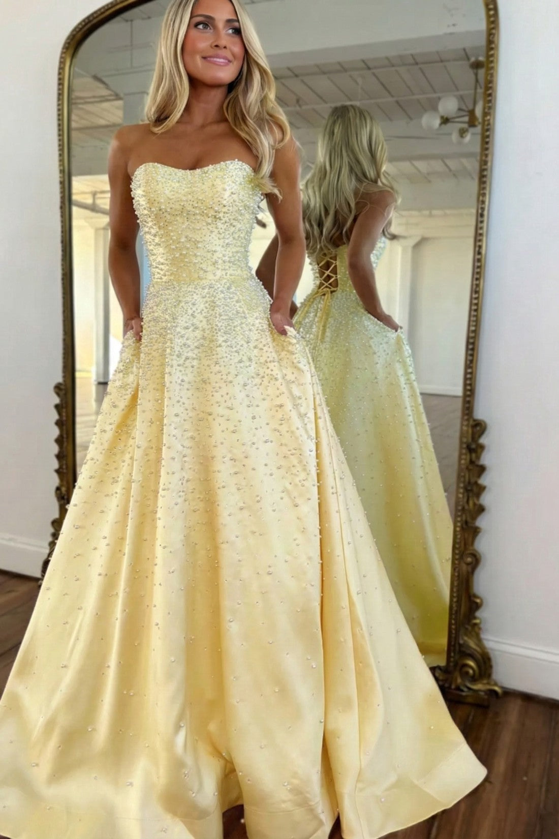 Vestido largo de satén con escote corazón sin tirantes, pedrería y bolsillos laterales, ideal para fiestas de graduación y como invitada de boda