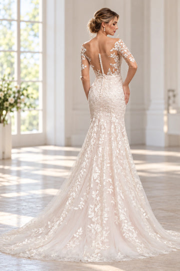 Back view of Vedress mermaid wedding dress featuring a sheer scoop back, covered buttons, leafy lace motifs and a flowing tulle train.