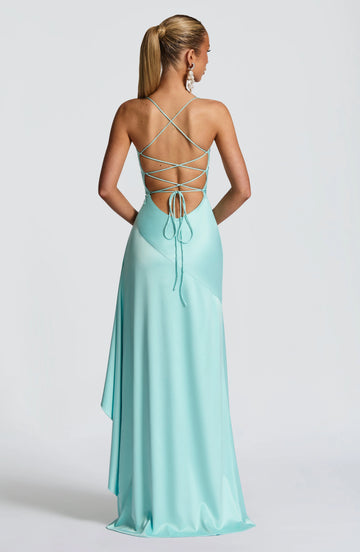 Back view of aqua maxi prom dress featuring an open back, crisscross lace-up straps, adjustable tie closure, and flowing skirt by Vedress.