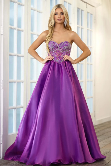 Glamorous A-line prom gown with strapless sweetheart neckline, fully beaded rhinestone bodice, sheer illusion panel and flowing lustrous satin skirt with sweep train