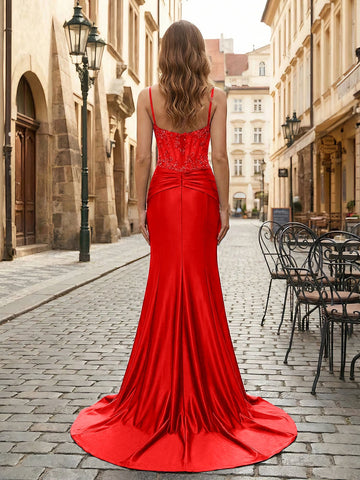 Back view of a red mermaid prom dress with a low scoop back, beaded detailing, center zipper and sweeping train.