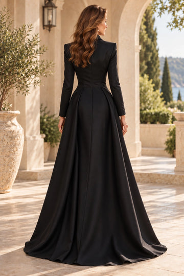 Back view of black mother of the bride dress featuring a structured long-sleeve bodice, closed back, fitted waist and flowing floor-length A-line skirt.