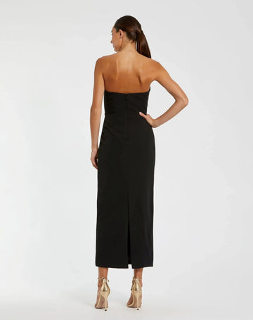 Black strapless sheath wedding guest dress with center zipper back and midi length back view