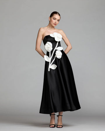 Black strapless A-line wedding guest dress with oversized white 3D floral appliqués front view