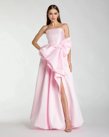 Blush pink strapless A-line prom dress with oversized waist bow and thigh-high slit front view