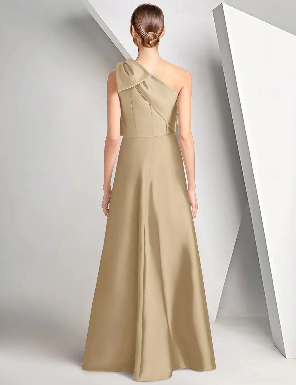 Back view of one-shoulder satin formal gown with shoulder bow, center back closure, and flowing A-line floor-length skirt
