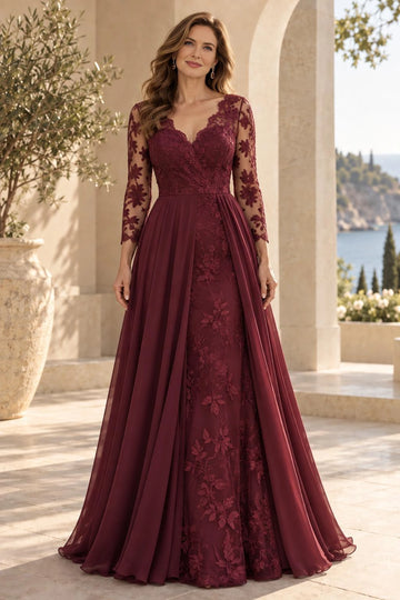 Burgundy mother of the bride dress with V-neck floral lace bodice, sheer three-quarter sleeves, fitted lace skirt and flowing floor-length side overskirt