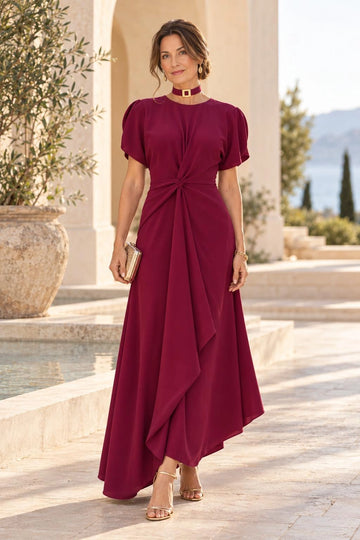 Burgundy A-line mother of the bride dress with round neckline, short puff sleeves, twisted draped waist, asymmetric high-low skirt and matching buckle choker.