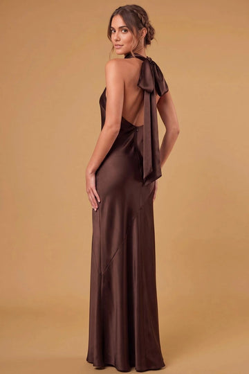 Back view of chocolate brown halter bridesmaid dress with a deep open back, oversized neck bow, long ribbon ties, center-back zipper, and floor-length skirt.