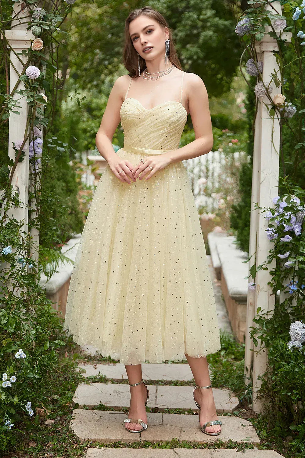 A-line tulle homecoming dress with sweetheart neckline, spaghetti straps, star-glitter detail, and bow waist