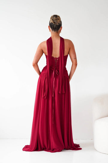 Dark red wedding guest dress with lace-up corset back and flowing floor length skirt by Vedress