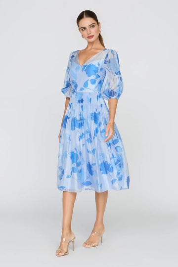 Light blue floral midi dress with V-neck, puff sleeves, A-line skirt, and soft chiffon-style overlay for wedding guest and cocktail occasions
