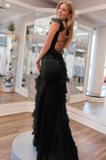 Back view of black satin formal dress with open lace-up back, ruffle strap detail, fitted silhouette, and ruffle slit skirt by VEDRESS