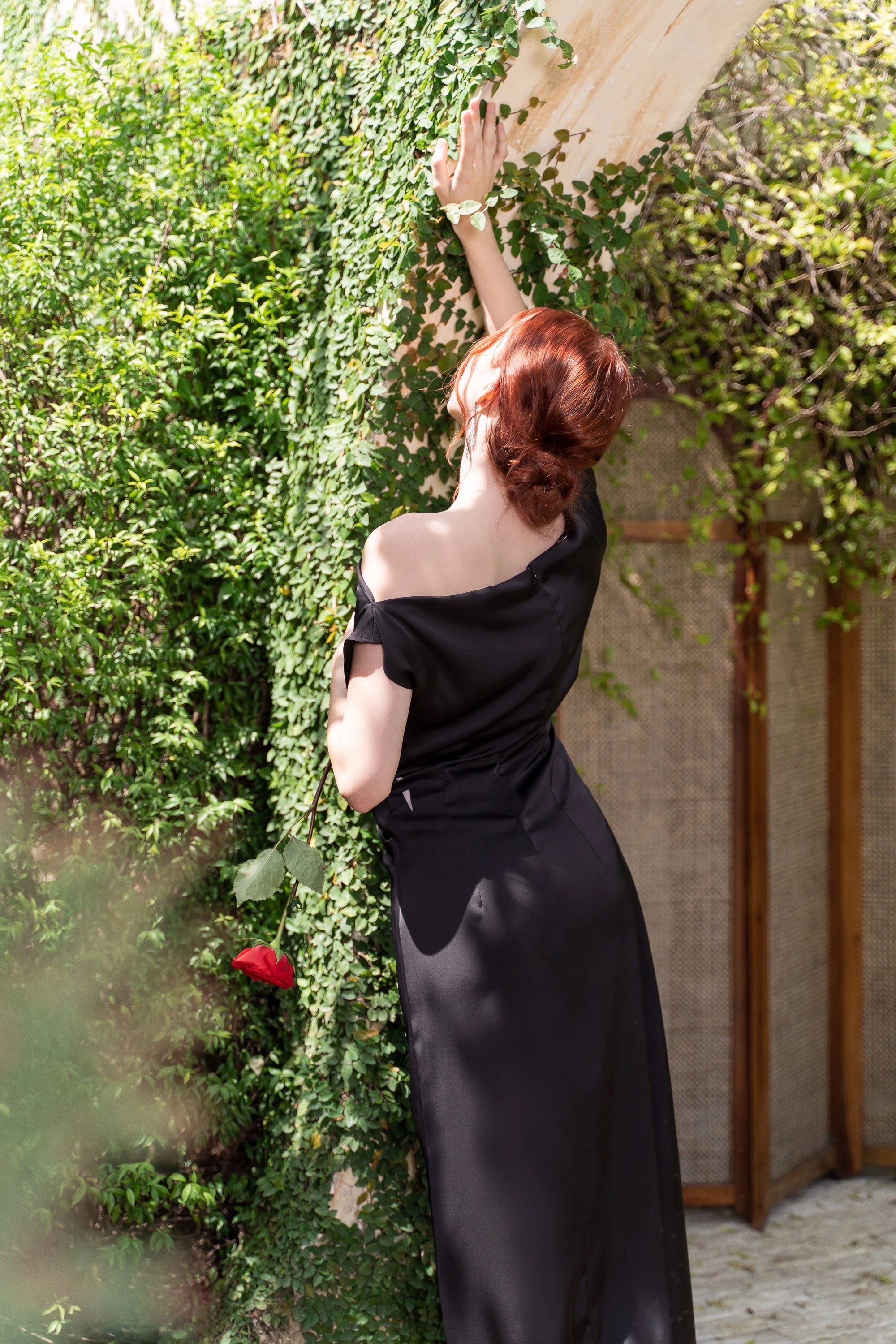 Back view of Vedress off‑shoulder satin sheath evening gown with invisible zipper back