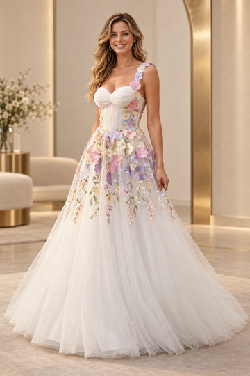 Front view of a Vedress ivory tulle wedding dress with pastel floral appliqués, a ruched sweetheart bodice, floral straps and a floor-length A-line skirt.