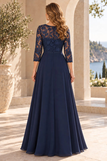 Back view of navy blue mother of the bride dress featuring sheer floral lace back, center zipper, three-quarter lace sleeves and flowing A-line skirt