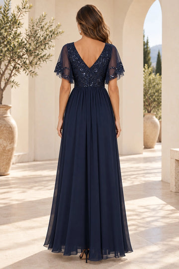 Back view of navy blue mother of the bride dress featuring V-shaped lace back, center zipper, sheer flutter sleeves and flowing A-line skirt