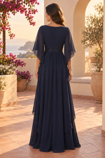 Back view of navy blue mother of the bride dress with covered zipper back, sheer flutter sleeves, embellished waistband and flowing layered A-line skirt