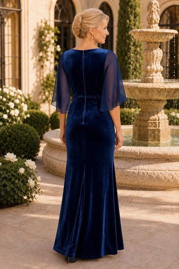Back view of navy blue velvet mother of the bride dress with center zipper, sheer flutter sleeves, fitted waist and gently flared floor-length skirt