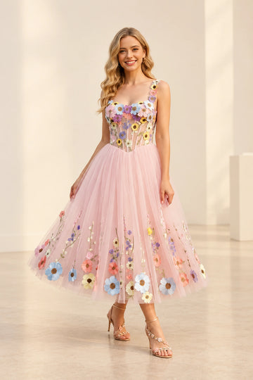 Front view of a Vedress pink tea-length wedding guest dress with colorful floral appliqués, a sheer scoop-neck bodice and an A-line tulle skirt.