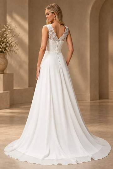 Back view of lace wedding dress with V-shaped illusion back, covered buttons, and flowing train