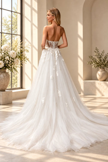 Back view of Vedress A-line wedding dress shown without sleeves, with an illusion corset-style back, buttons and a sweeping floral train.