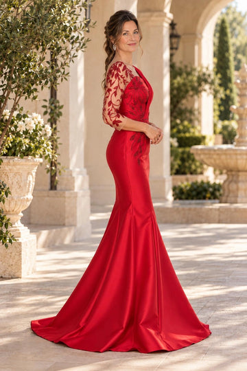Red mermaid mother of the bride dress with asymmetric neckline, pleated shoulder draping, sheer three-quarter beaded sleeve, leaf embellishments and sweep train.