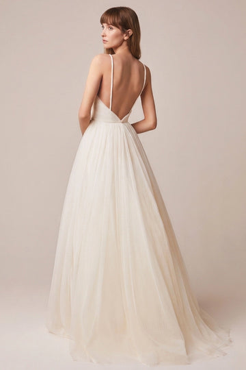 Ivory A-line tulle wedding dress with deep V-shaped open back, delicate spaghetti straps and flowing bridal skirt back view