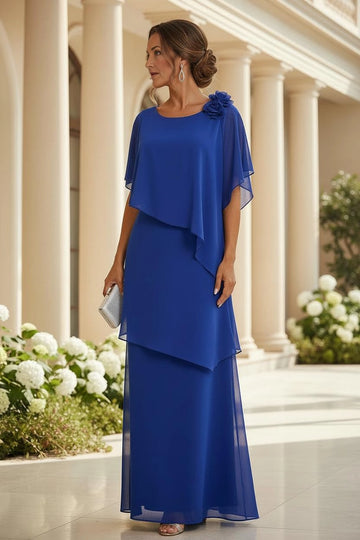 Royal blue A-line mother of the bride dress featuring round neckline, sheer cape-style sleeves, floral shoulder embellishment and flowing layered floor-length skirt, front view.