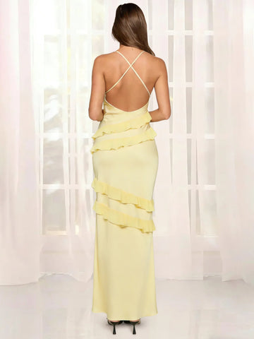 Back view of butter yellow backless maxi dress with crisscross straps, open back design, and layered ruffle details