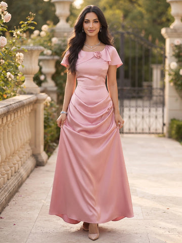 Front view of a pink satin Vedress wedding guest dress with a rosette scoop neckline, short flutter sleeves and draped ankle-length skirt.