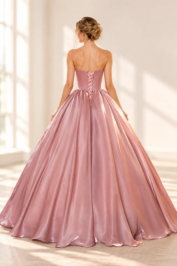 Back view of a Vedress pink satin prom dress with a ribbon lace-up bodice, exposed shoulders and a full floor-length ball gown skirt
