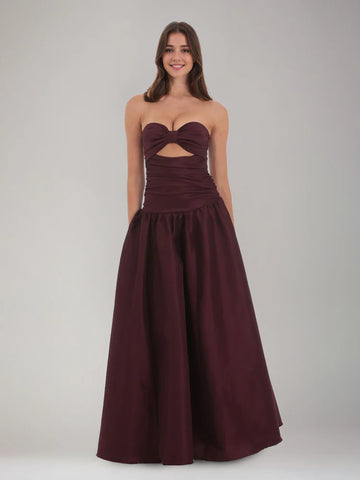 Burgundy strapless sweetheart satin formal dress with bow front, cutout bodice, ruched waist, and A-line skirt