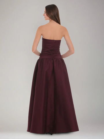 Back view of burgundy strapless satin formal dress with ruched bodice, center zipper, and full A-line skirt