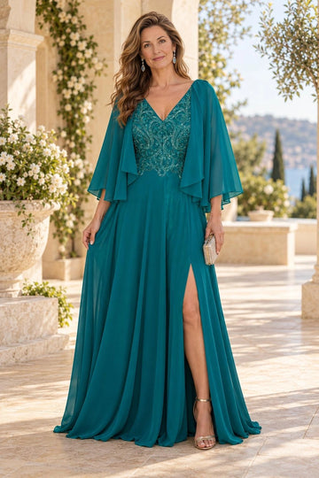 Teal A-line mother of the bride dress with an embellished V-neck bodice, swirling beadwork, sheer cape sleeves, front slit and flowing floor-length skirt.