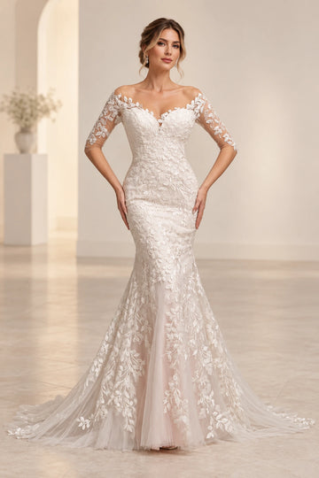 Vedress mermaid wedding dress with an illusion sweetheart neckline, sheer elbow-length sleeves and leafy vine lace flowing into a train.